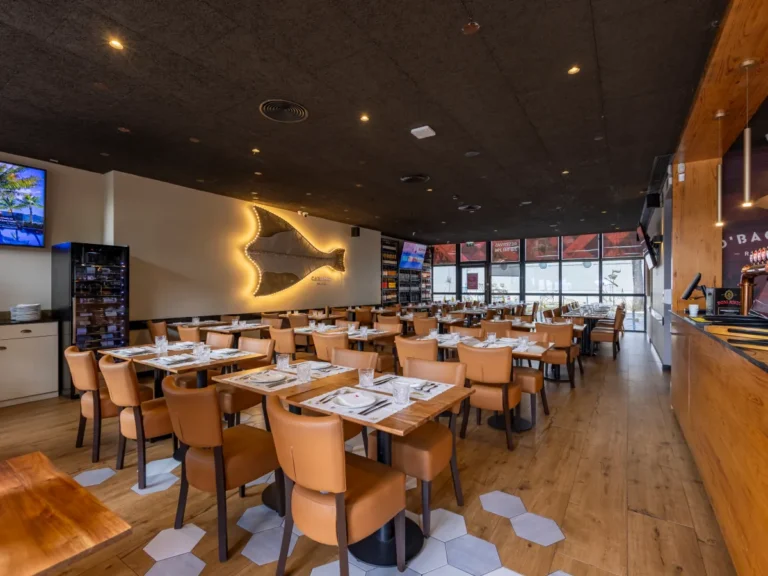 Sala com a escultura de bacalhau iluminada na parede