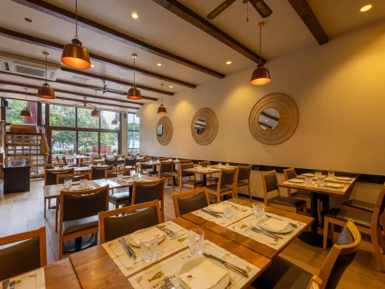Sala do restaurante com espelhos redondos e mesas postas